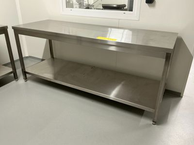 une table en acier inoxydable au milieu d'une pièce