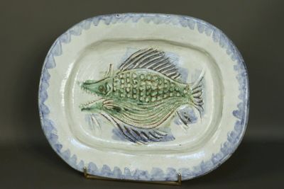 une assiette avec un poisson dessus, posée sur une table