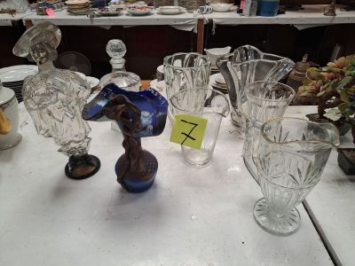 une table sur laquelle se trouvent de nombreux objets en verre