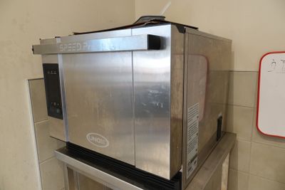 un micro-ondes argenté posé sur un socle métallique