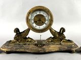 une horloge posée sur une table à côté de trois bougies
