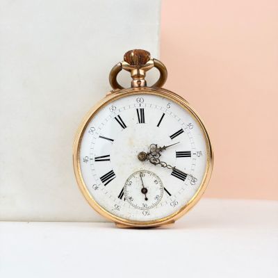 une montre de poche en or avec des chiffres romains
