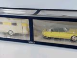 a yellow car and a white car in a display case