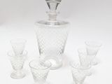 four glasses and a decanter sitting on a table