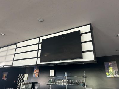 un téléviseur fixé au mur au-dessus d'un bar