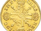 a close up of a gold coin with a cross on it