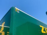 a green semi truck with a yellow and yellow logo on the side