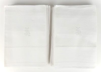two white towels with embroidered monograms on them on a white surface