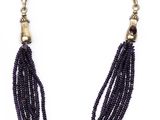 a close up of a necklace with black beads on a white background