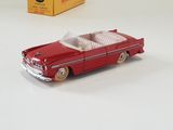 a red toy car sitting next to a box on a table