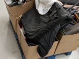 une boîte remplie de vêtements, posée par terre