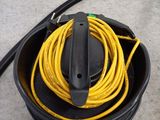 a yellow cord in a black bucket on the floor