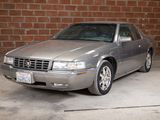a silver car that is parked in front of a brick wall