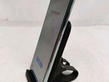 a close up of a cell phone on a stand on a white surface