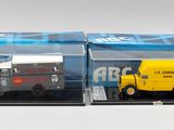 deux camions miniatures dans une vitrine posée sur une surface blanche