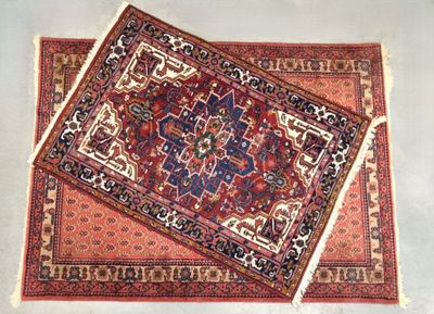 Grand tapis en laine à décor de boteh sur fond rose et un ta…