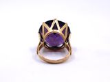 a close up of a ring with a purple stone in it