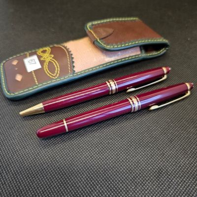 deux stylos et un étui posé sur une table, dans lequel se trouve un stylo