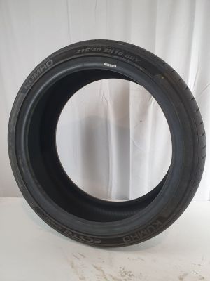 a close up of a tire on a white surface with a curtain in the background