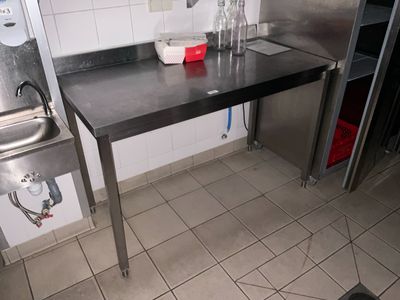 une cuisine équipée d'une table en inox et d'un évier