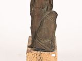 statue of a woman sitting on a stone block with a white background
