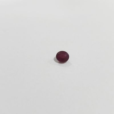 an oval shaped red ruby stone on a white surface