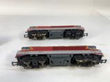 two model trains sitting side by side on a white surface