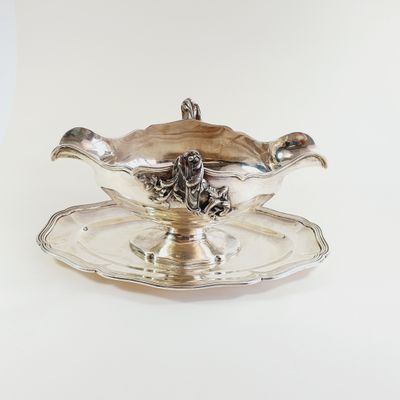 a silver plate with a silver saucer on it