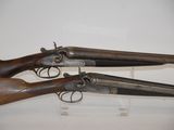 two old guns are on display in a glass case