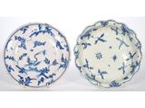 two blue and white plates with birds and flowers on them