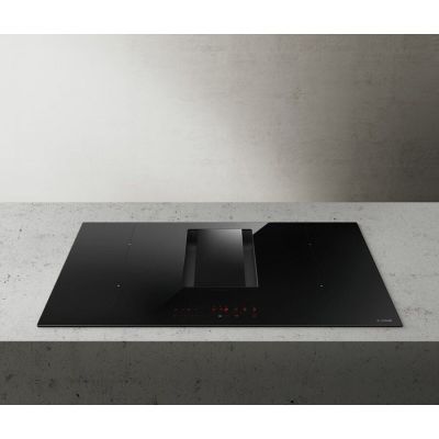 a black stove top sitting on top of a counter next to a wall