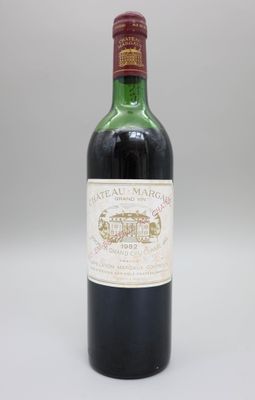 une bouteille de vin rouge posée sur une table blanche