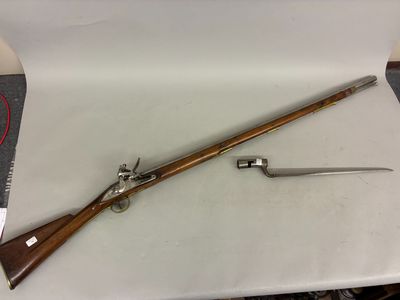 an old rifle with a wooden handle and a knife on a table