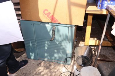 une boîte posée par terre à côté d'un ventilateur