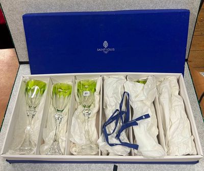 une boîte bleue contenant quatre verres à vin et des serviettes