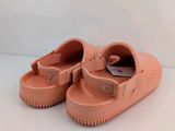 a close up of a pair of pink shoes on a white surface
