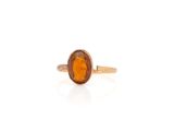 a close up of a gold ring with an orange stone