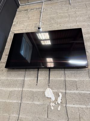 un téléviseur à écran plat posé par terre devant un mur