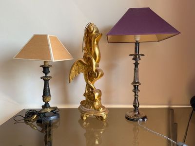 une table sur laquelle se trouvent une lampe, un abat-jour et une statue