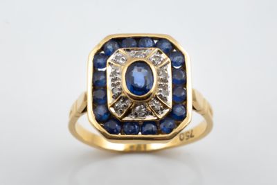 a close up of a gold ring with blue sapphires and diamonds
