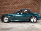 an image of a green sports car parked in front of a brick wall