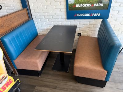 a booth with two benches and a table with a laptop on it