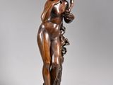 an antique bronze statue of a woman holding a basket of flowers