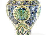 a blue and yellow vase sitting on a white surface