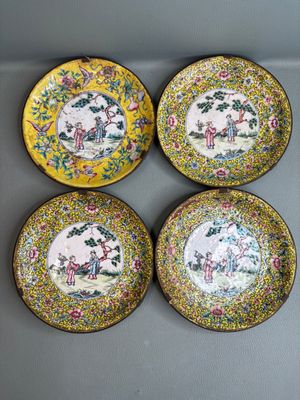 four yellow and blue plates with flowers and birds on them