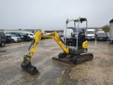 the back end of a small excavator parked in a parking lot