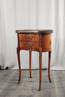 une vieille table en bois avec un plateau en marbre, posée sur un parquet