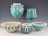 three vases and a bowl are sitting on a table