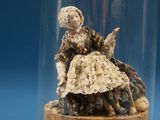 a figurine of a woman in a dress under a glass dome