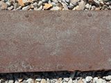 a rusted piece of metal sitting on a pile of rocks